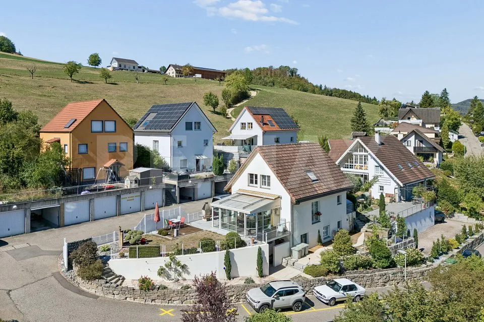 Idylle résidentielle ensoleillée avec une vue lointaine et un jardin aménagé avec soin