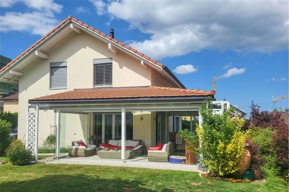 Maison de famille attrayante de 4½ pièces avec grand jardin d'hiver. Située au soleil et au calme.