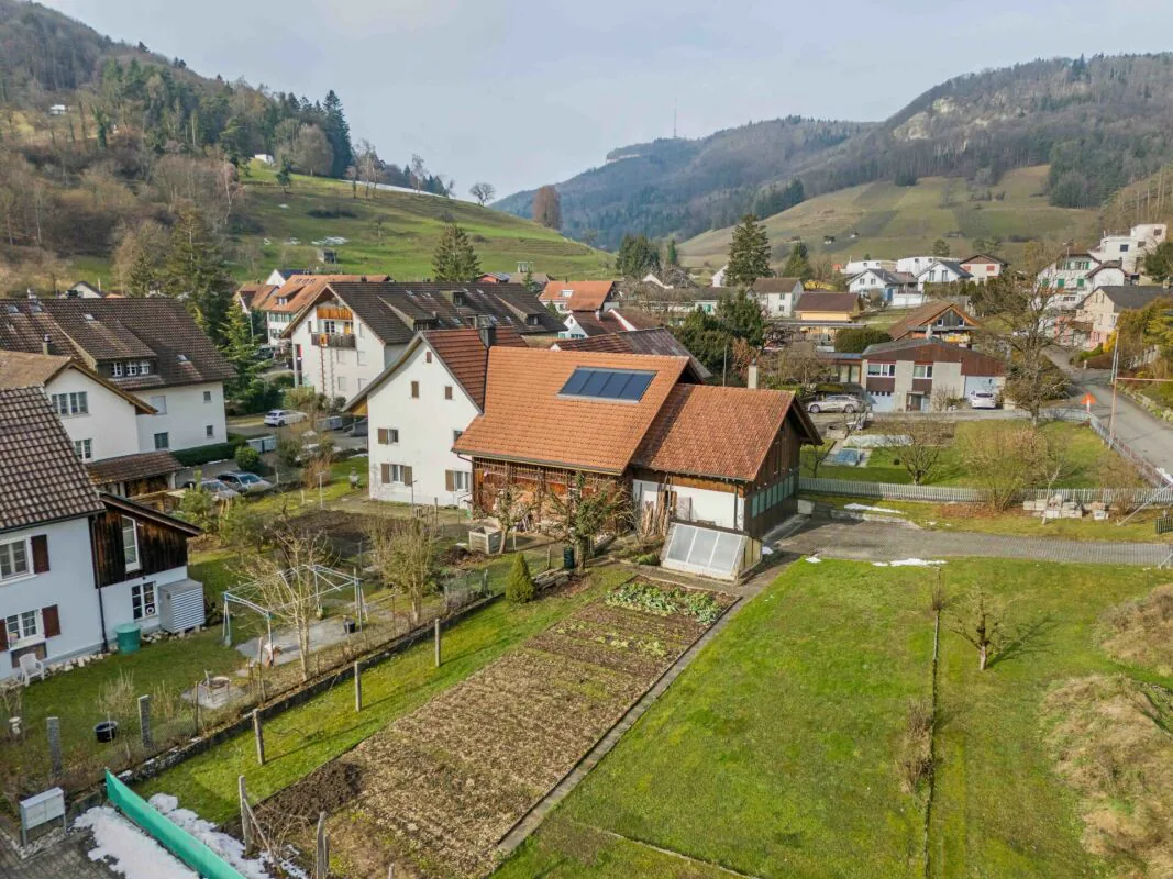 Terreno edificabile di oltre 1'758 m² con una casa a due famiglie e grande potenziale di sviluppo nel centro del villaggio tranquillo di Remigen
